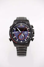 Black Casio watch with blue-red subdials, red second hand, black metal bracelet.
