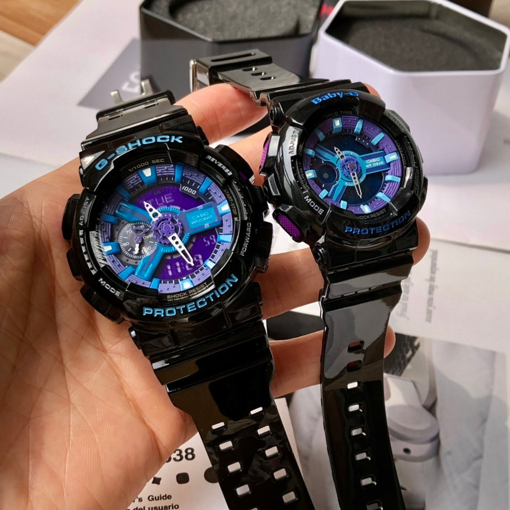 Two black G-Shock watches on a hand, blue and purple dials and textured resin straps