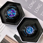 Two G-Shock watches in foam inserts, black cases with blue and purple dial displays