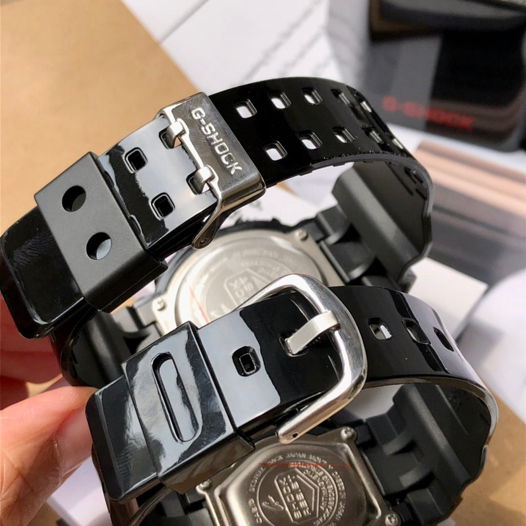 Black resin watch strap detail with metal buckle and underside case hardware
