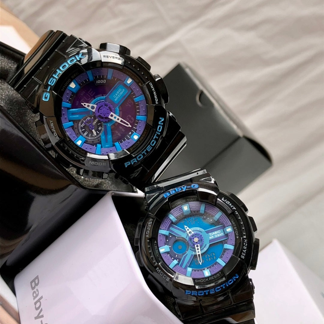 Black G-Shock watch pair in resin cases, blue and purple dials with metal hands