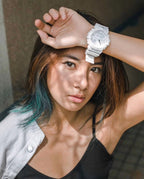 Casio watch on wrist with white strap and round digital face