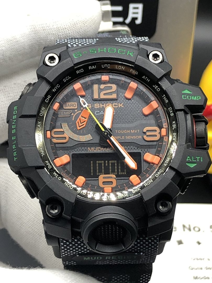 Casio watch face with orange hour markers, black multi-function bezel