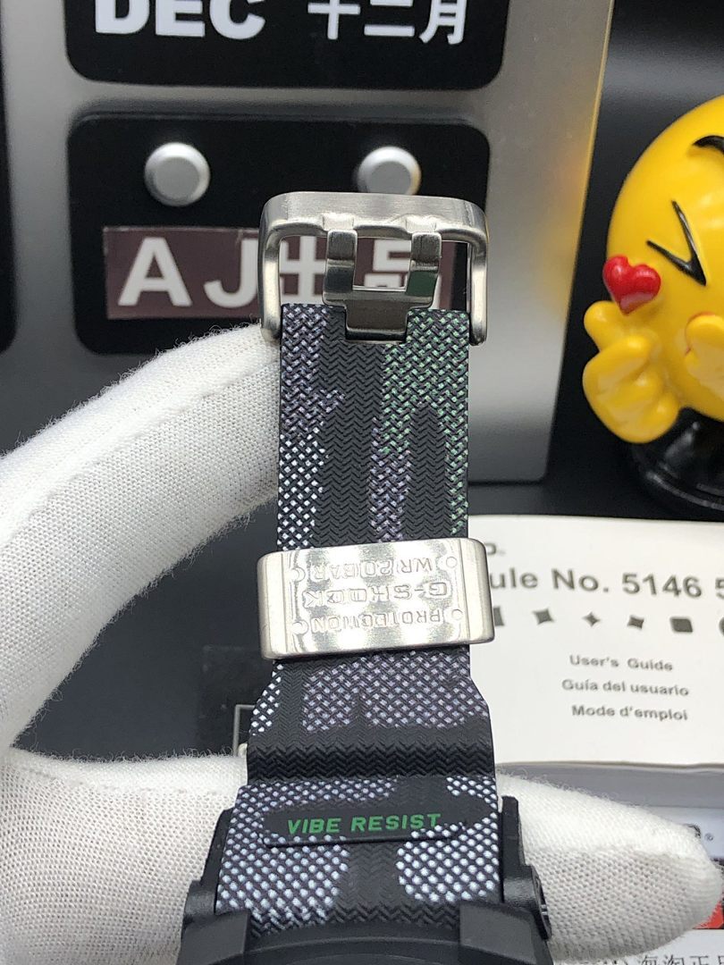 Casio watch buckle with black and green textured strap on metal clasp