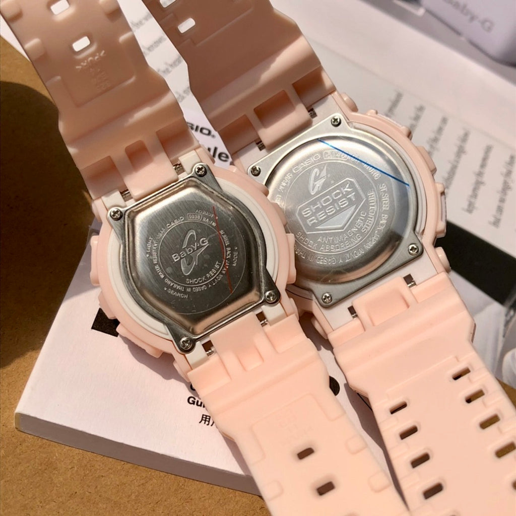Close-up of light pink resin watch backs with engraved case plates and screws