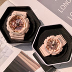 Two wristwatches in open cases with light pink resin straps and round multi-dial faces