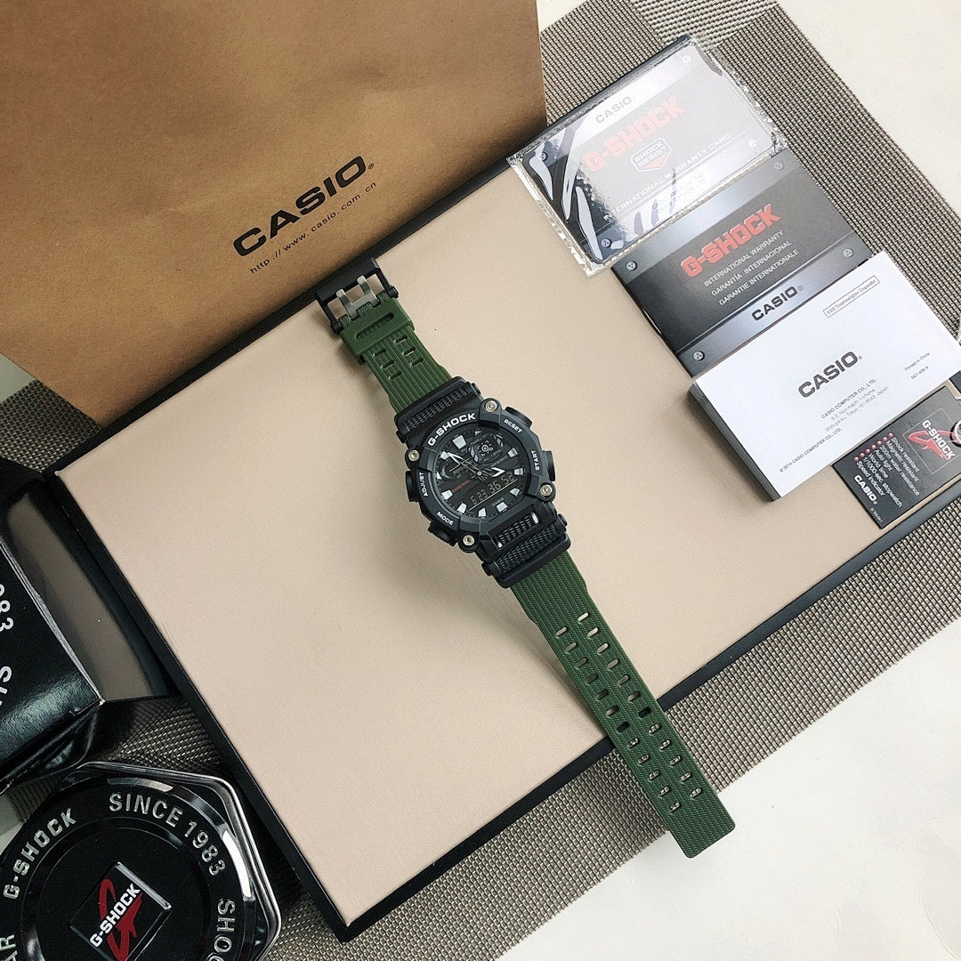 Casio G-Shock wristwatch with green strap beside presentation box and papers