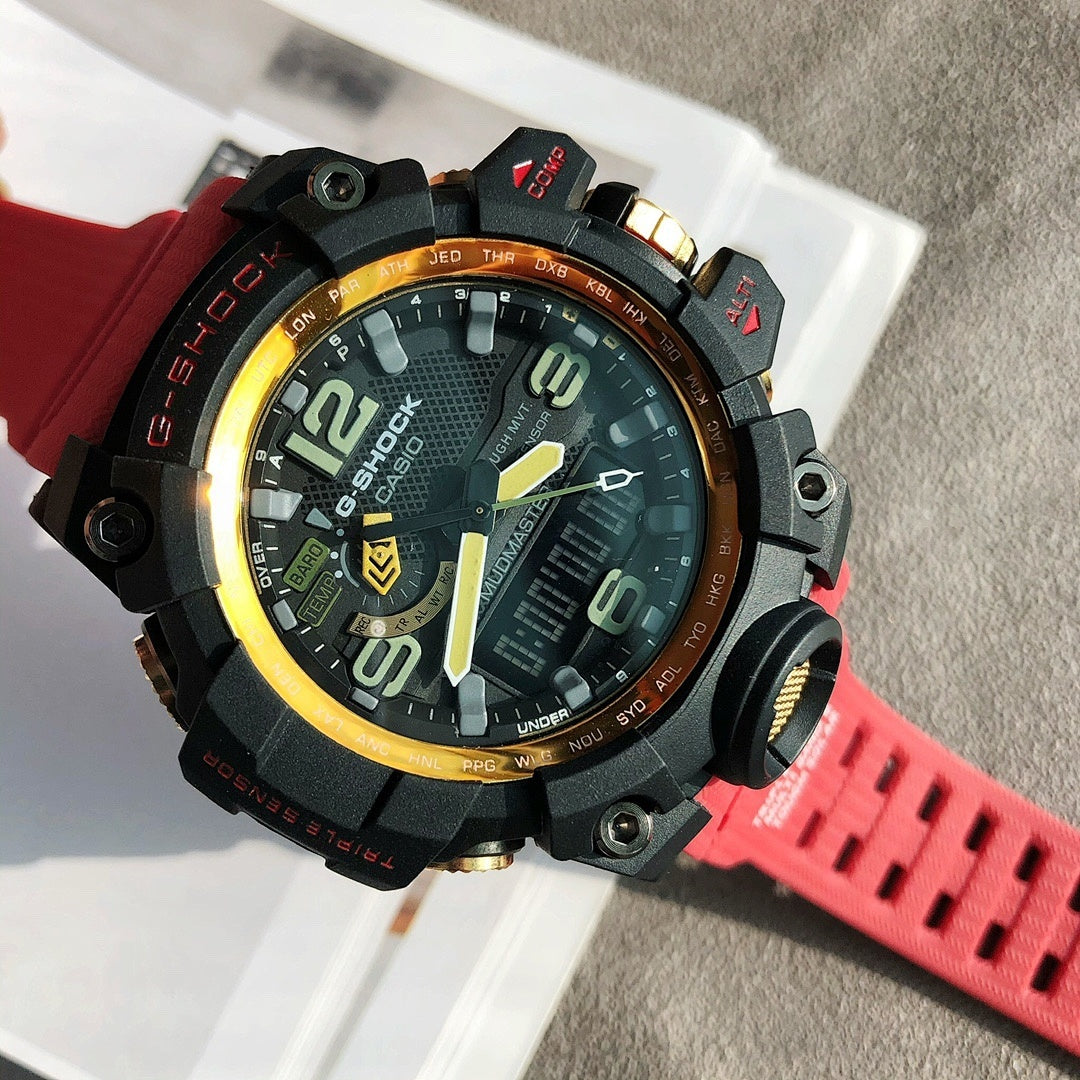 G-Shock digital watch with black case, gold rim, and red rubber strap