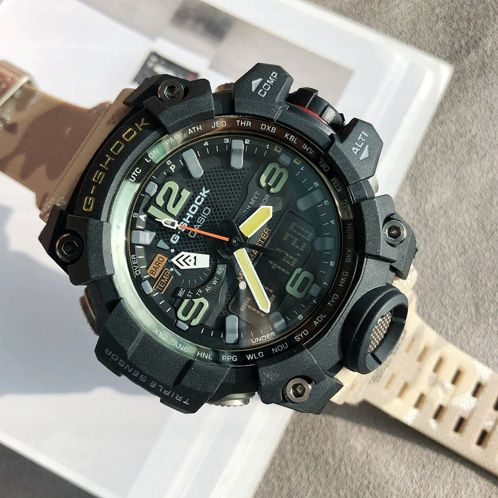 G-Shock digital watch with black case, bright orange hands, and beige perforated strap