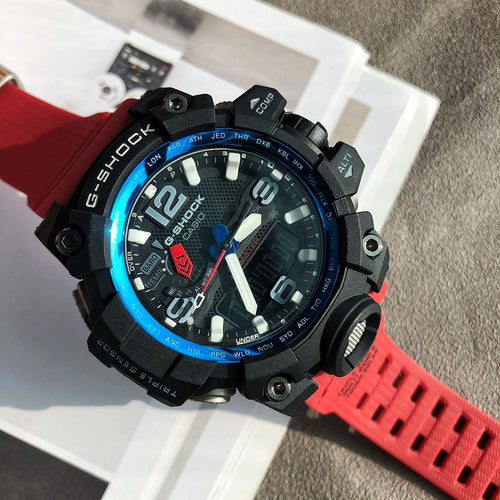 G-Shock digital watch with black case, blue bezel ring, and red rubber strap