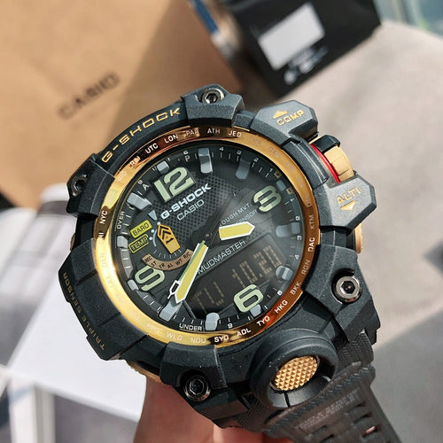 G-Shock digital watch with dark case, gold accents, and green dial on rugged strap
