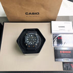Casio watch shown with black dial and black resin strap in a box setup