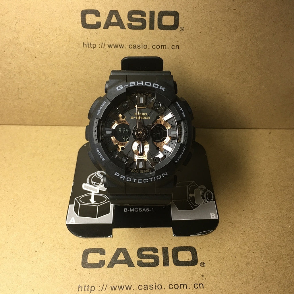 Casio G-Shock watch with black case, gold-tone dial, and metallic hour markers.
