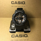 Casio G-Shock watch with black case, gold-tone dial, and metallic hour markers.