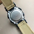 Round watch case back with metal cover and black-and-beige strap ends.