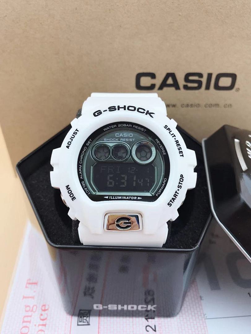 Casio G-Shock digital watch with green LCD screen and white case, thick bezel