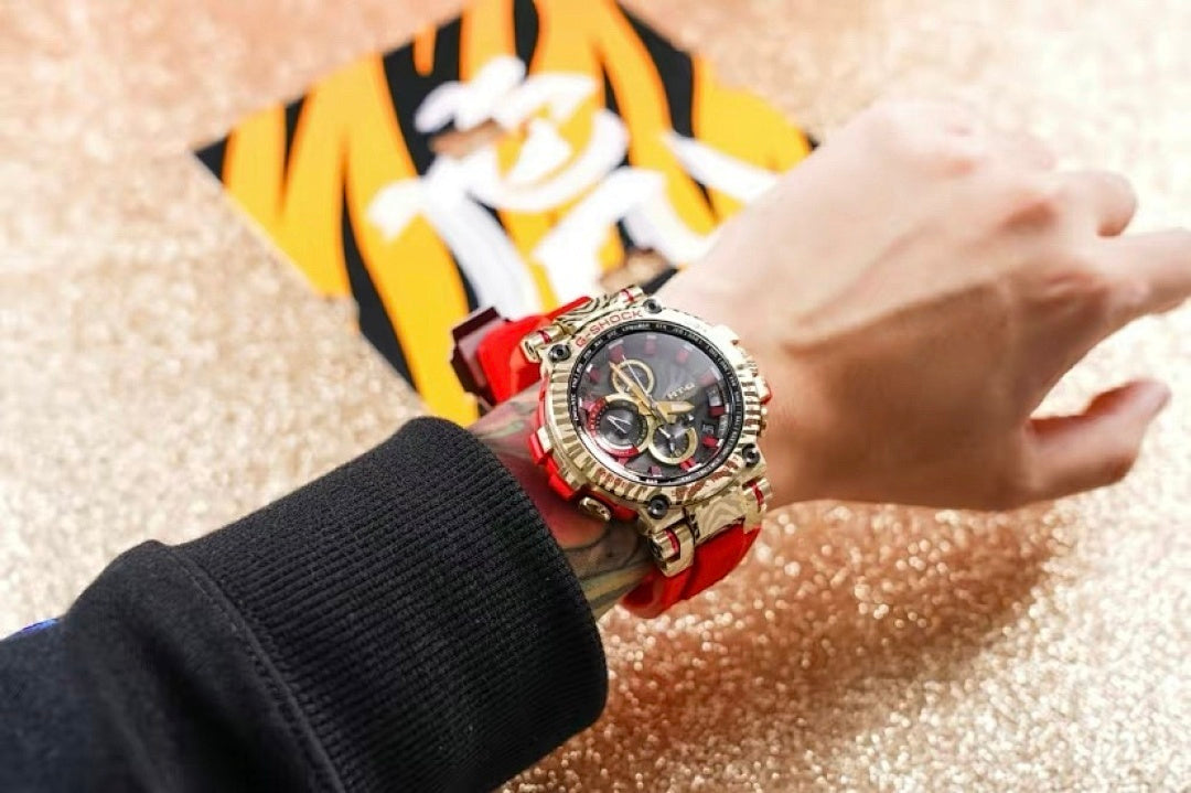 Casio G-Shock watch on wrist, red strap and gold-tone bezel with black chronograph dial