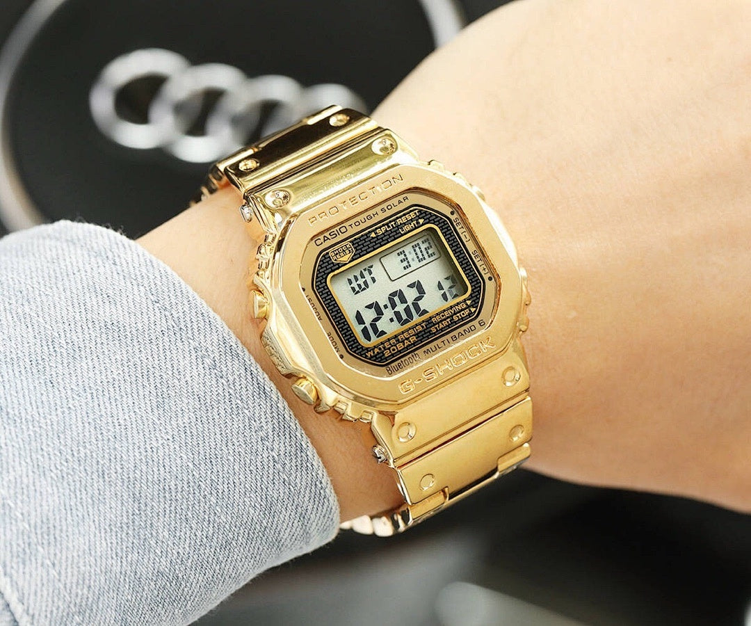 Gold-tone metal digital watch worn on wrist
