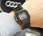 Black metal digital G-Shock watch with red-accent bezel