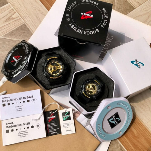 Casio G-Shock and Baby-G watches in display boxes, black straps with gold dials.