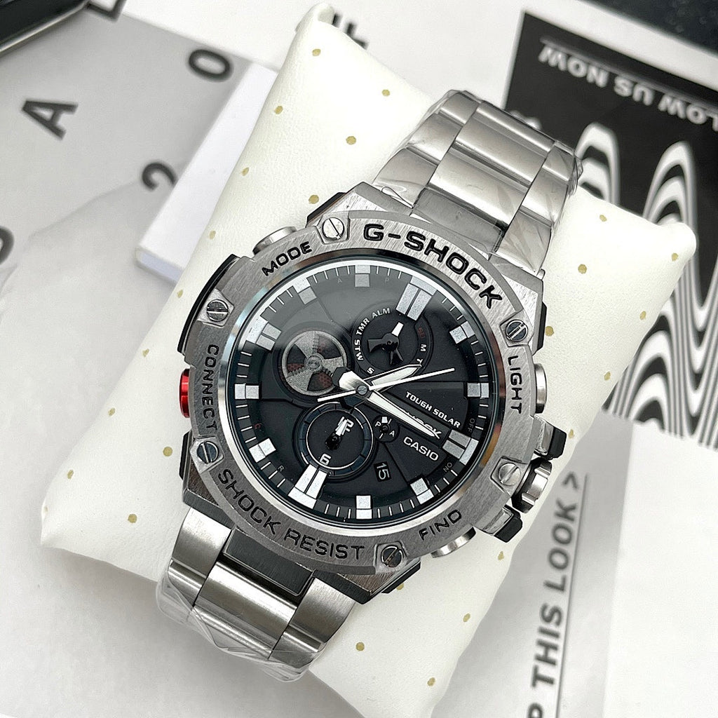 Casio G-Shock wristwatch on white cushion, black dial and stainless steel bracelet
