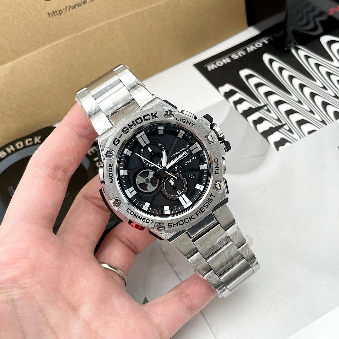 Casio G-Shock wristwatch held in hand, black dial and stainless steel bracelet