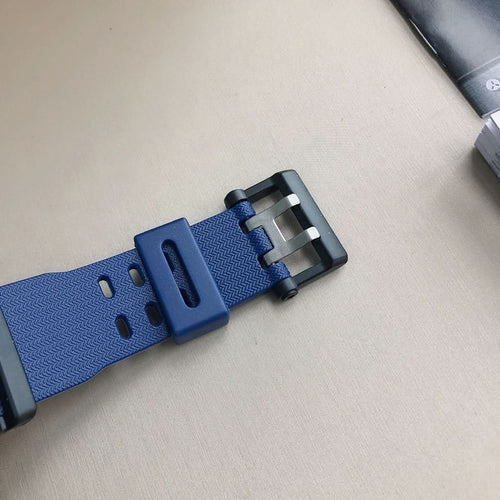 Casio G-Shock watch band close-up with blue resin buckle and strap holes