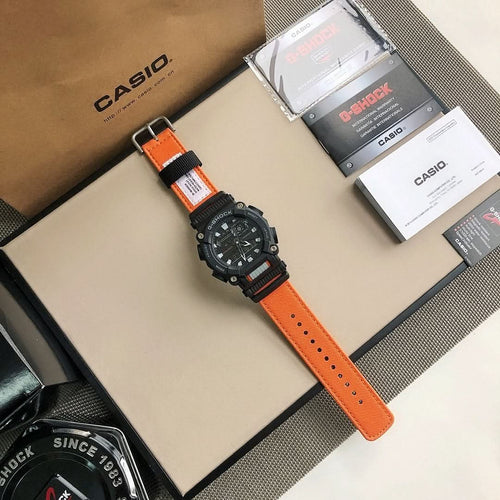 G-Shock wristwatch with orange strap and black dial on a display tray