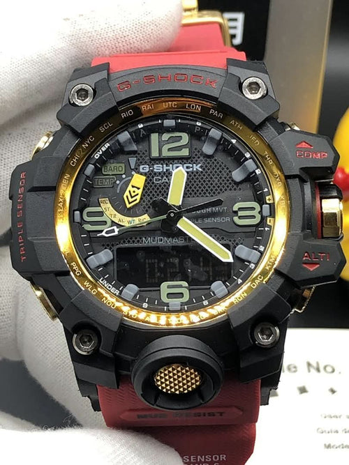 Casio sports watch, black case with gold rim, red band, analog-style dial close-up