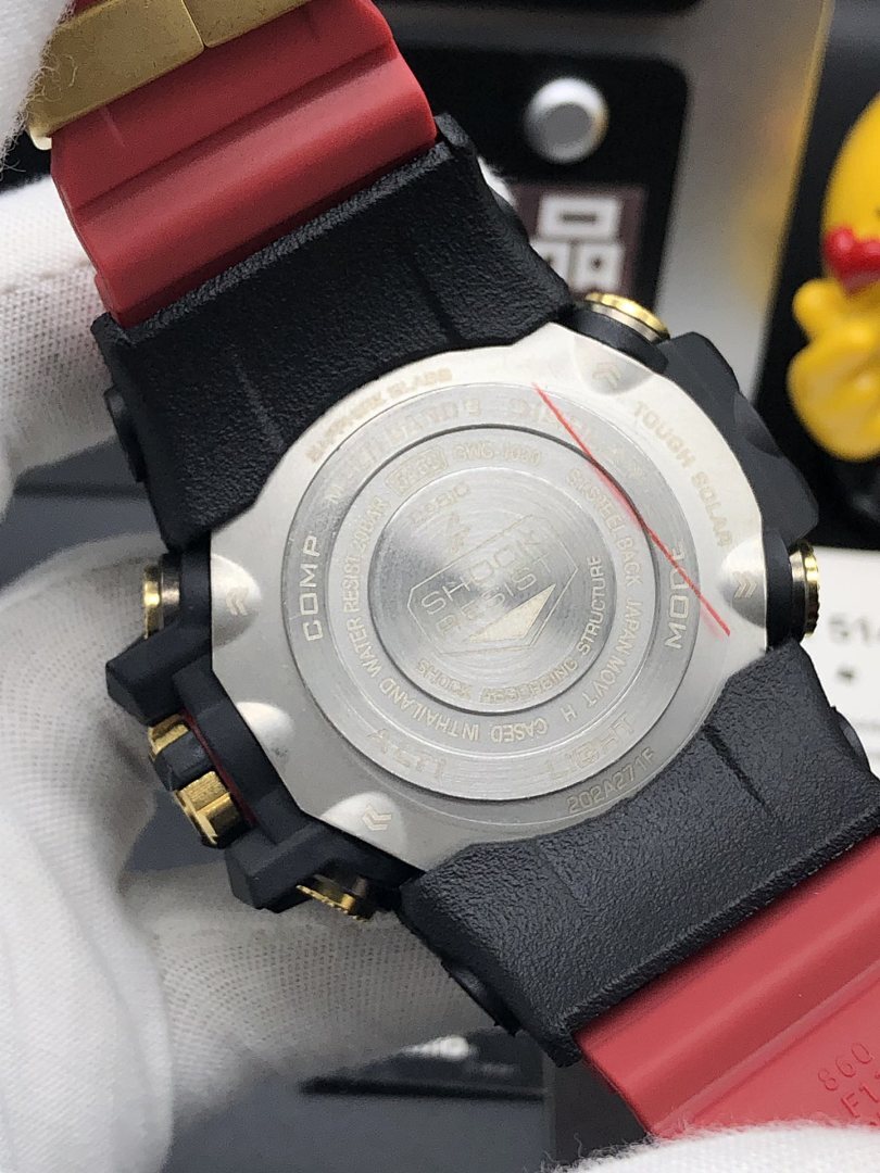 Casio watch backplate with engraved details, black case back, red silicone strap