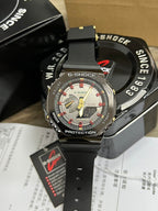 G-Shock watch with black resin strap and silver-toned case, gray dial with red highlights