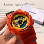 Orange G-Shock wristwatch worn on a hand, showing blue dial and yellow ring
