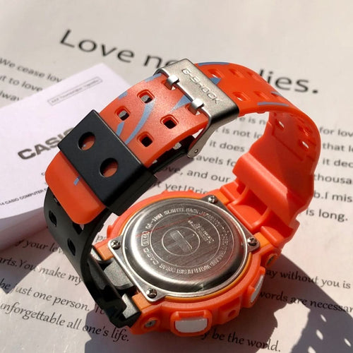 Orange G-Shock wristwatch with round metal caseback and black strap buckle