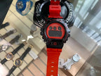 Red digital G-Shock-style watch with LCD screen and red rubber strap.