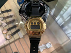 Gold digital G-Shock-style watch with LCD display and black rubber strap.