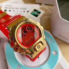 Casio G-Shock watch with gold case and red resin strap, close-up red LCD