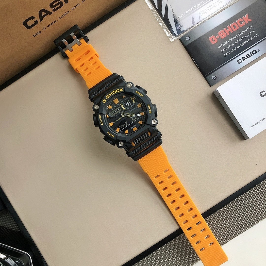 G-Shock wristwatch with black dial and orange rubber band laid flat