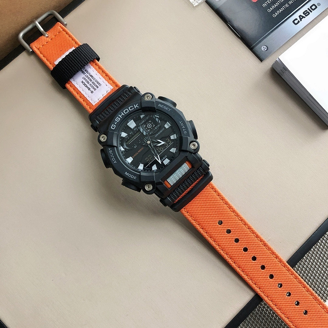 G-Shock digital wristwatch with orange perforated strap and black case, close angle.