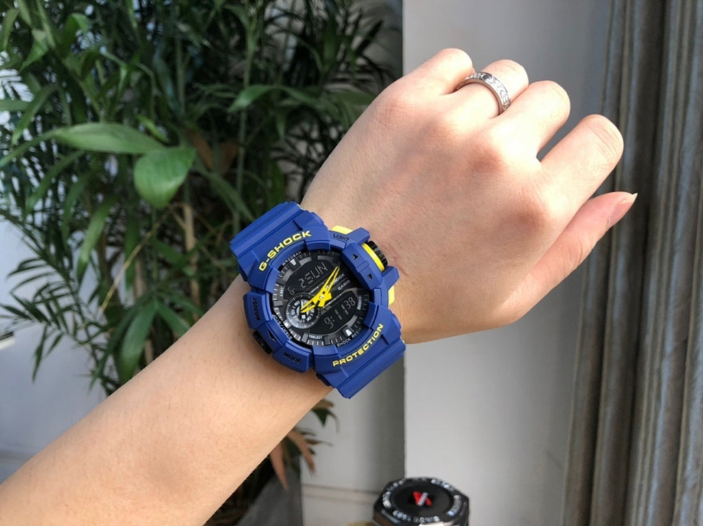 Casio G-Shock blue watch worn on wrist, black dial with yellow accents