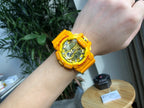 Casio watch with yellow resin strap on wrist, round digital face