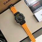 Casio G-Shock watch with orange resin strap and black round bezel with yellow details.