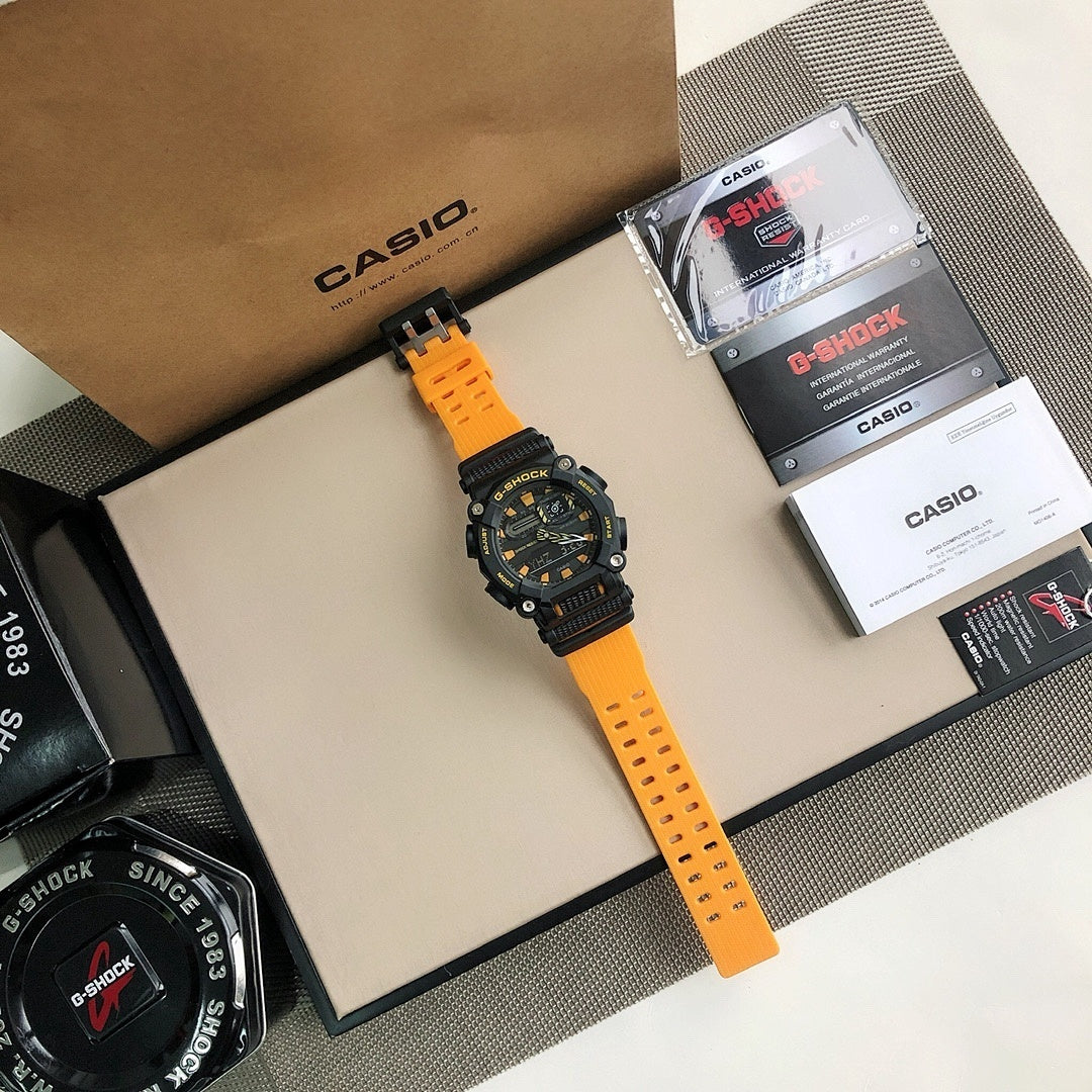 Casio G-Shock watch on bright orange resin strap, black bezel with dial markings.