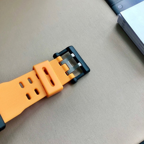 Orange resin watch strap with black buckle and adjustment holes.