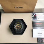 Casio G-Shock wristwatch in black cushion with gold-toned dial and black strap