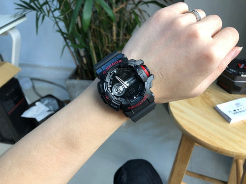 Casio G-Shock watch on wrist, black resin band with red details and round display
