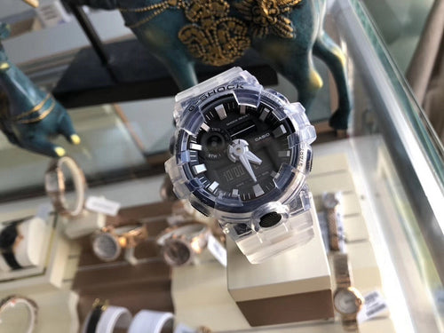 Casio G-Shock watch on display stand, clear resin strap and black dial