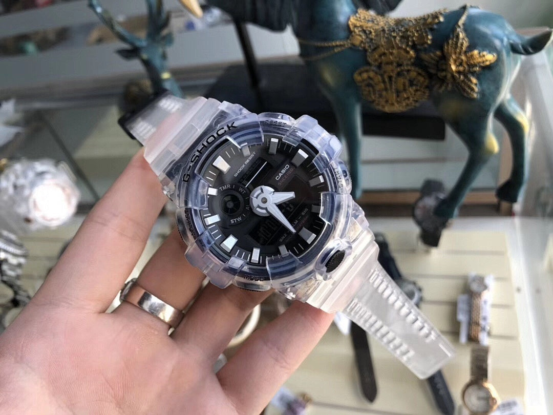Casio G-Shock watch in hand, clear resin strap and black face with three hands