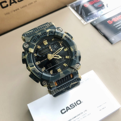 G-Shock style wristwatch with blue camo strap, black round dial, and gold accents