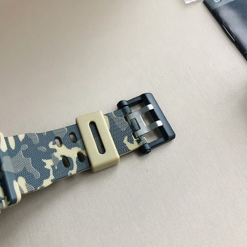 Wristwatch strap close-up in blue camo with tan buckle and metal clasp