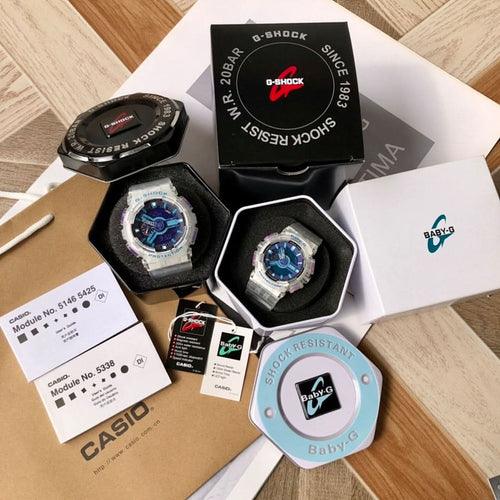 Two Casio watches in open boxes: black and clear blue-dial models
